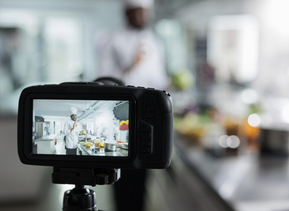 Close up camera recording gastronomy expert in restaurant kitchen filming culinary course while cooking delicious dish. Head chef vlogging preparing of gourmet food for gastronomic course on internet.